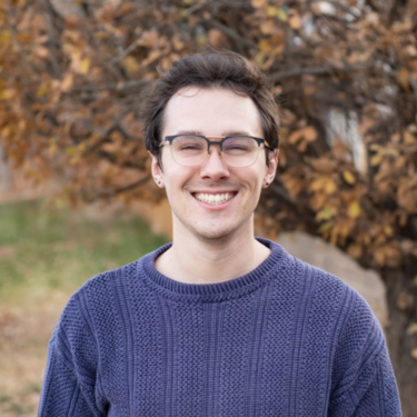 Hyde Weissenfluh smiling in front of a tree in autumn.