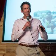 David Drake leads a talk from the front of a bar in downtown Boulder.