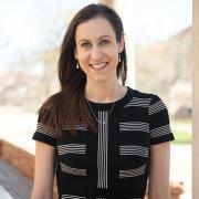 Alix Barasch outside on the CU campus in a black dress.