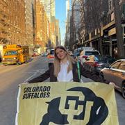 Lily Combs holding a Buffs flag on the streets of New York.