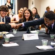 Members of the winning Business Leadership Program team celebrate their victory by fist bumping.