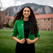 Trisha Tyagi smiles at the camera while posing on campus.