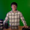 Braden Stirret poses in front of a green screen with film equipment surrounding him.