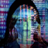 A woman stands in front of a projection of brightly colored numbers and charts