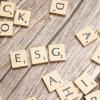 Scrabble tiles strewn across a table; several tiles spell "ESG"