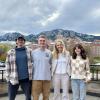 Four Sustainability Scholars undergraduate students smiling on the CU Boulder campus with the Flatirons in the background