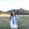 Peyton Biggers poses in front of the Flatirons with her graduation stoll