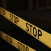 Yellow tape with the word "Stop" repeated on it against a black background