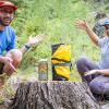 A man and a woman pose outdoors with a packraft.