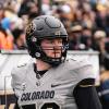 Camden Dempsey looks out of frame while geared up during a CU football game.