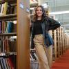 Chloe Theil stands in a library