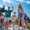 New students walk as parents cheer them on at orientation.