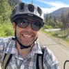 Court Rye takes a selfie on his bicycle. Another cyclist is visible in the foreground.