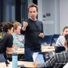 Mike DelPrete leads a classroom discussion in casual dress.