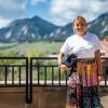 Emily Campbell stands on the Koelbel Building deck with the Flatirons in the background.