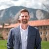Ezra McPhail poses on campus with the Flatirons in the background