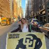 Lily Combs holding a Buffs flag on the streets of New York.