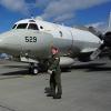 Taylor Hartley in front of a fleet of military jets on a runway.