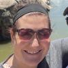 Laurel Harman takes a selfie in a mountain park next to her husband.