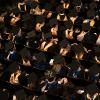 Business school graduates, from above, seated at a commencement ceremony.