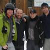Four men in winter gear stand in front of a ski hotel in Utah.