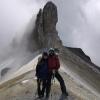 Aaron Friedland and friend posing in front of a rocky structure on a hike. 