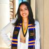Jordyn in her graduation regalia and Diverse Scholars Program hood.