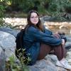 Julie Gentile sits beside a creek in the middle of the woods.