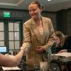 A student and Omni employee shake hands at the start of a presentation.