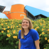 Katie Morton smiling in front of a flower bush
