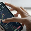 A person looks at financial data on a phone