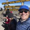 Henry Coote smiling in from of the top of Mount Kilimanjaro