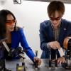 Camila and Johnny working with a laser in their 3D printing lab.