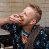 James Fogerty biting into one of his waffle creations at his kitchen. He's really enjoying it.