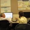 instructor assisting a student at a computer screen