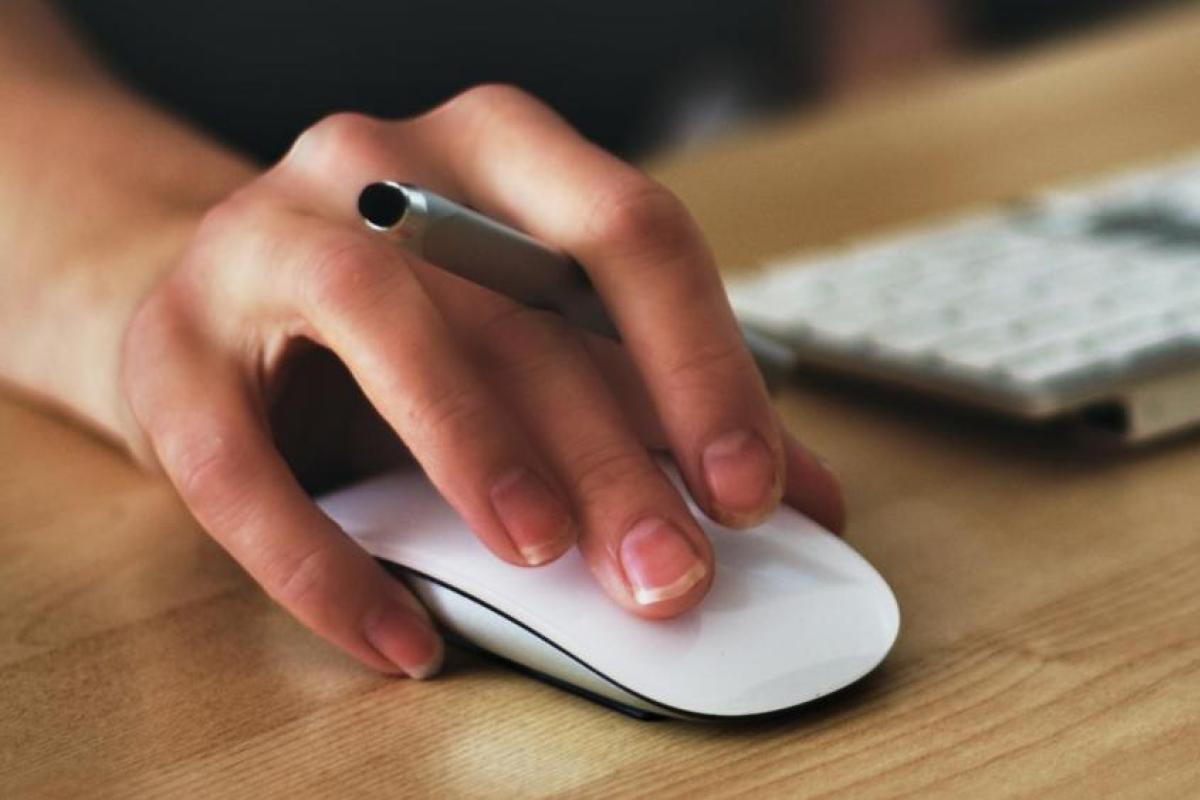 person clicking on a laptop with a mouse