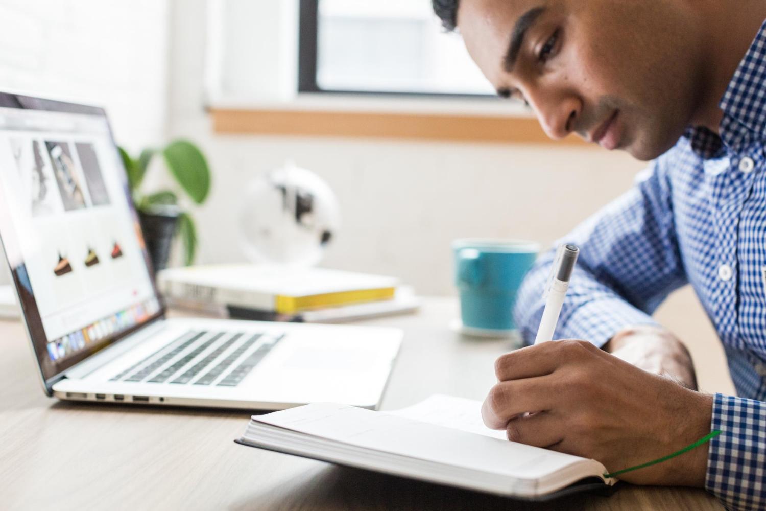 man writing in a notebook
