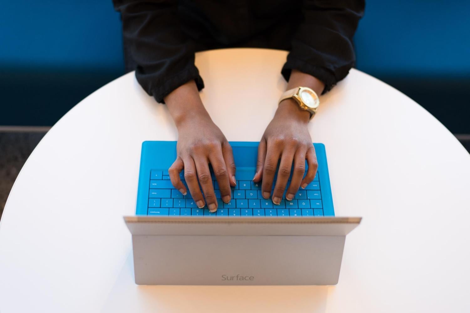 person typing on a blue keyboard