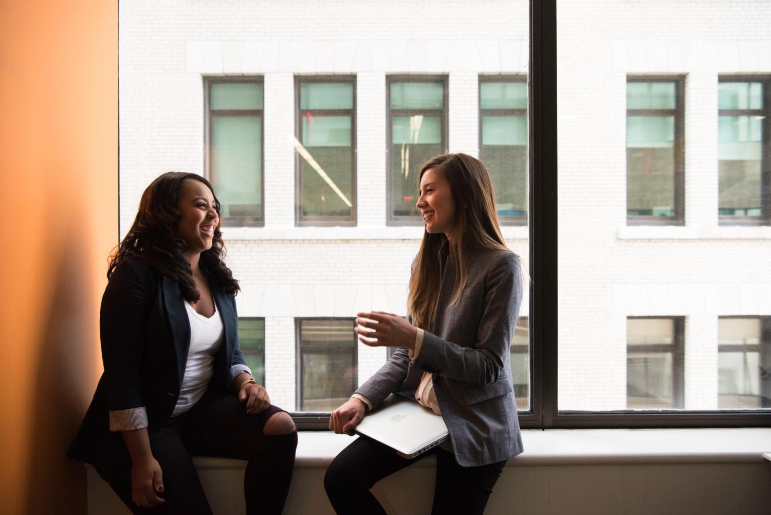 two people talking in front of a window
