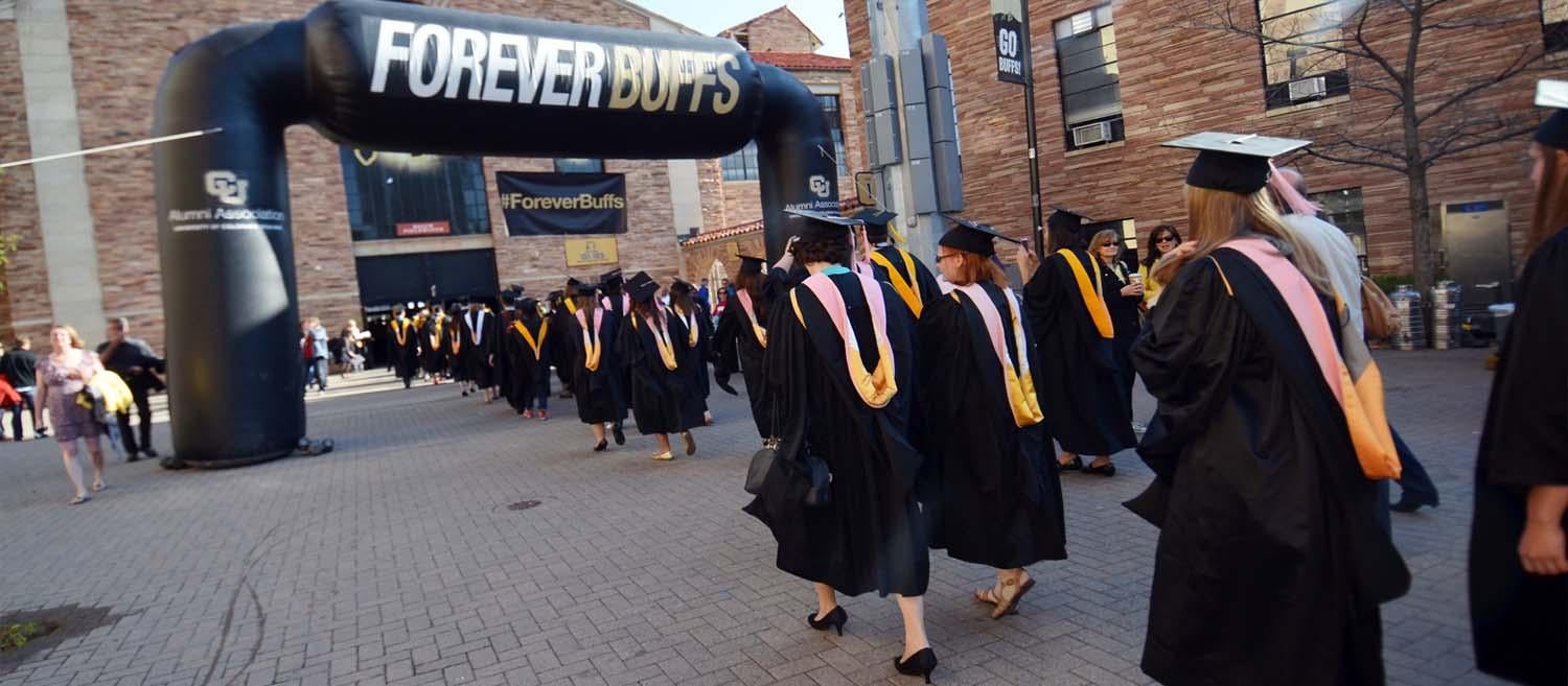 graduates walking under forever buffs banner