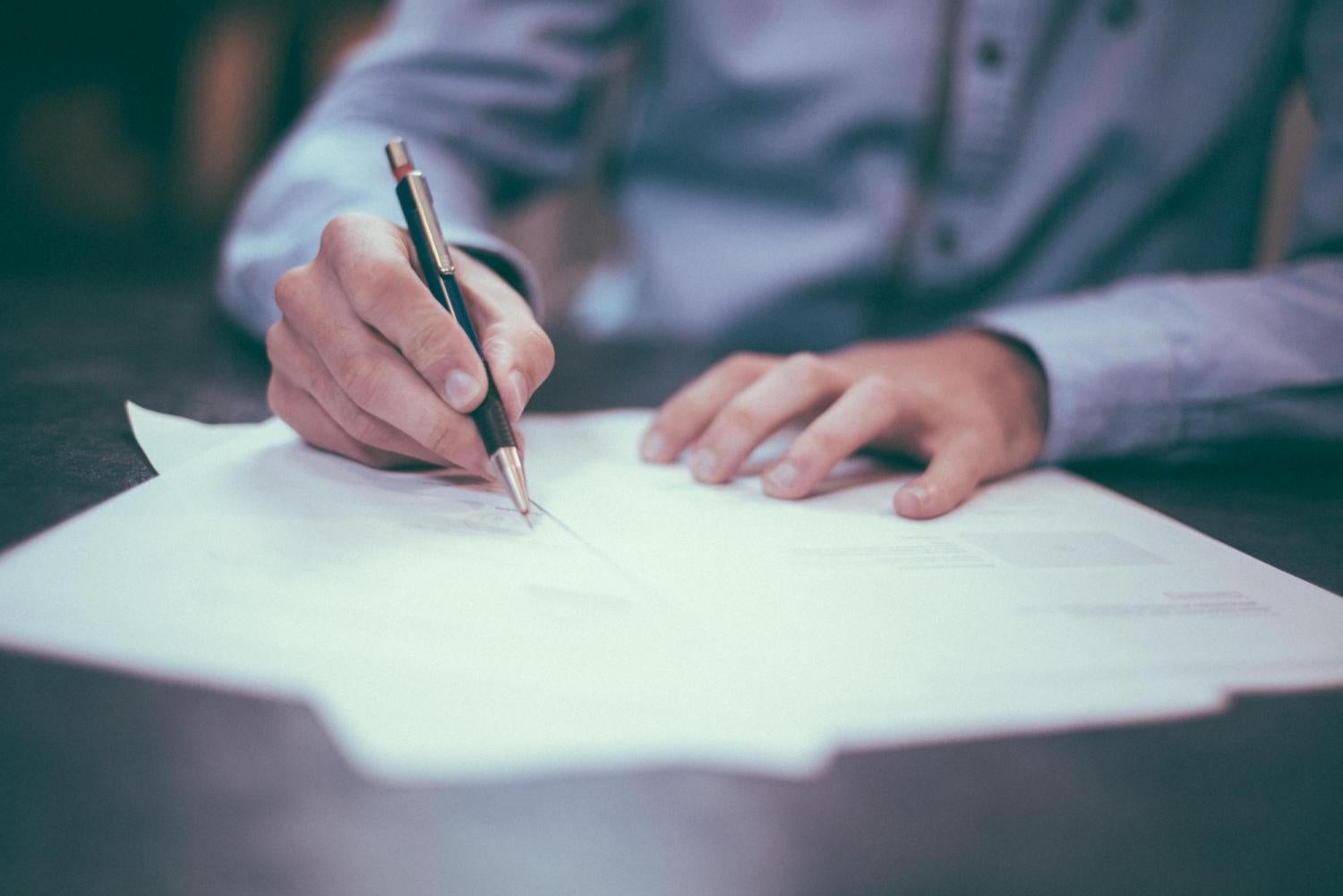 person writing on a piece of paper