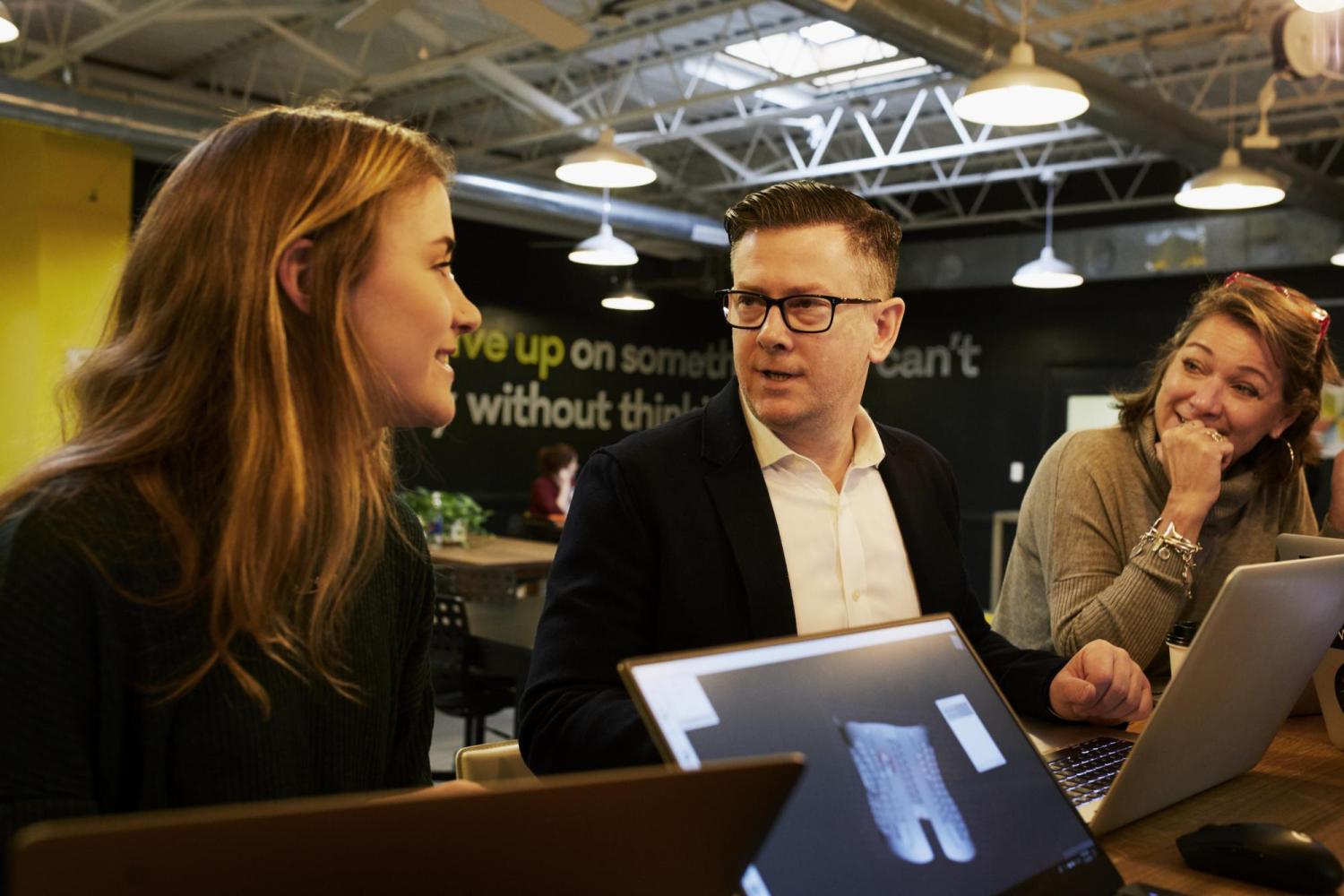 man talking with two women