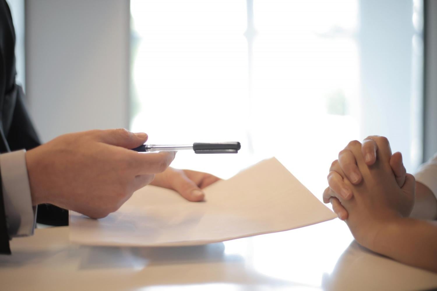 two people talking over a piece of paper