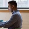 Male student sitting at a desk working on a computer
