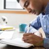 man writing in a notebook