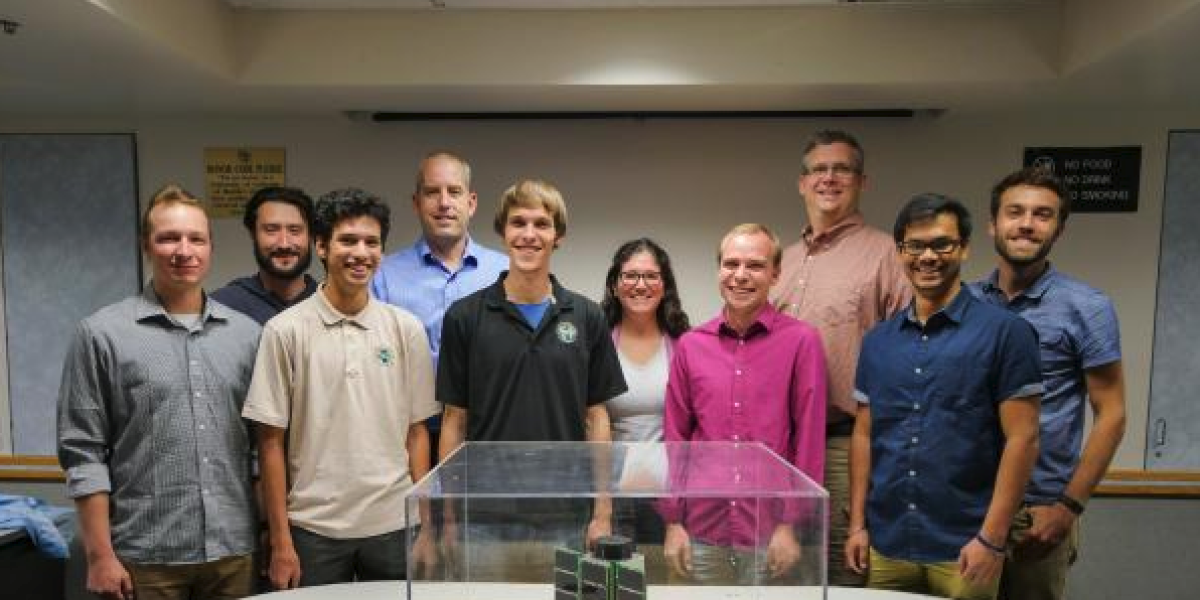 Members of the Challenger team with the microsatellite before it left CU Boulder.