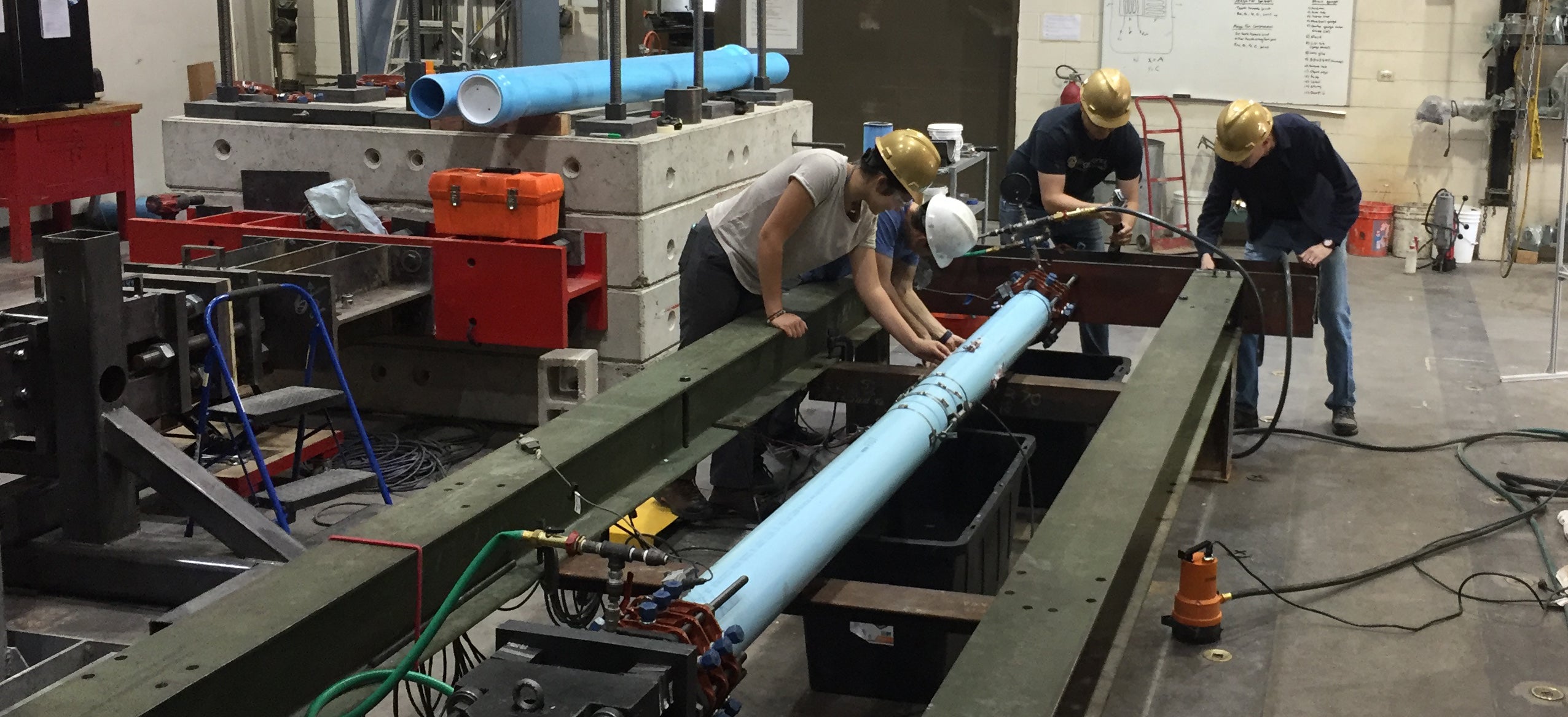 Researchers work on a pipe testing project in the CIEST lab