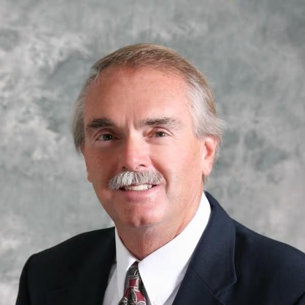 Donald R Clark in a suit. Clark has a mustache.