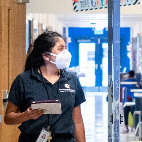 Two students walking in a school hallway.