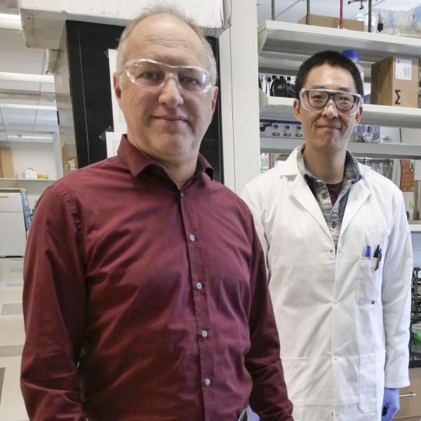 Karl Linden and Ben Ma wearing protective glasses in the lab.